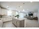 Open concept kitchen with granite counters, island, and views of the living room at 18813 W Solano Dr, Litchfield Park, AZ 85340