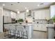 Modern white kitchen features an island with seating and updated appliances at 18813 W Solano Dr, Litchfield Park, AZ 85340