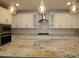 Modern kitchen featuring granite countertops, white cabinets, and stainless steel appliances at 18813 W Solano Dr, Litchfield Park, AZ 85340