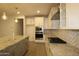 Well-lit kitchen with modern appliances, granite countertops, and a tile backsplash at 18813 W Solano Dr, Litchfield Park, AZ 85340