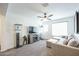 A spacious living room with plush sofa and a TV over a fireplace, illuminated with ceiling fan at 18813 W Solano Dr, Litchfield Park, AZ 85340