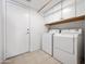 Clean laundry room with white appliances and ample storage space above the units at 20404 N 28Th Pl, Phoenix, AZ 85050