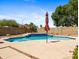 Beautiful backyard pool area with a decorative tile waterfall feature and lush desert landscaping at 20404 N 28Th Pl, Phoenix, AZ 85050