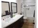 Bright bathroom with dual mirrors, white marble countertops, dark wood vanity, and a tiled shower and tub at 2060 E Quartz St, Mesa, AZ 85213