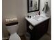 Cozy bathroom featuring white marble countertops and a dark wood vanity with convenient toilet paper storage at 2060 E Quartz St, Mesa, AZ 85213