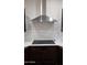 Modern cooktop and stainless range hood against a white subway tile backsplash at 2060 E Quartz St, Mesa, AZ 85213
