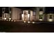 An evening scene featuring the home's grand entrance, illuminated with landscape lighting, providing a warm welcome at 2060 E Quartz St, Mesa, AZ 85213