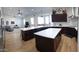 Spacious open kitchen featuring stainless appliances, island with white countertop, and dark cabinets at 2060 E Quartz St, Mesa, AZ 85213