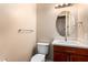 Powder room featuring a toilet, sink, and dark wood cabinet at 21401 E Russet Rd, Queen Creek, AZ 85142