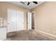 Bedroom features tan carpet, ceiling fan, and double door closet at 21401 E Russet Rd, Queen Creek, AZ 85142
