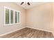 Bedroom featuring tile flooring and a large window with white shutters and a ceiling fan at 21401 E Russet Rd, Queen Creek, AZ 85142