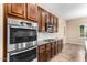 A kitchen featuring stainless steel appliances, dark cabinets, granite countertops, and tile flooring at 21401 E Russet Rd, Queen Creek, AZ 85142