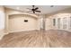 Spacious living room with wood-look tile flooring, neutral walls, ceiling fan and arched doorways at 21401 E Russet Rd, Queen Creek, AZ 85142