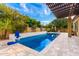 Backyard with a refreshing pool, basketball hoop, and travertine pavers at 21401 E Russet Rd, Queen Creek, AZ 85142