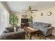Cozy living room featuring plush seating, a ceiling fan, and natural light streaming through the window at 2201 W Wethersfield Rd, Phoenix, AZ 85029