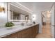 A modern bathroom features a lighted mirror, white countertop, wood cabinets, and modern fixtures at 2737 E Arizona Biltmore Cir # 8, Phoenix, AZ 85016