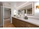 The modern bathroom features a lighted mirror, white countertop, wood cabinets, and modern fixtures at 2737 E Arizona Biltmore Cir # 8, Phoenix, AZ 85016