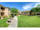 Grassy courtyard with a sidewalk, grill, bench, and seating area at 29606 N Tatum Blvd # 204, Cave Creek, AZ 85331