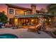Inviting backyard with a covered patio, stone accents, and a serene pool area at dusk at 3416 E Squawbush Pl, Phoenix, AZ 85044