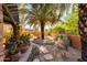 Beautiful desert backyard featuring mature landscaping, stone accents, and a serene ambiance at 3416 E Squawbush Pl, Phoenix, AZ 85044