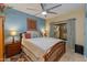 Comfortable bedroom with a ceiling fan, large bed, and a window with curtains at 3416 E Squawbush Pl, Phoenix, AZ 85044