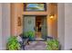 Inviting entryway featuring double doors, stone flooring, and a cozy bench with potted plants at 3416 E Squawbush Pl, Phoenix, AZ 85044