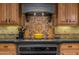 Close up of kitchen stove with custom tilework and cabinets at 3416 E Squawbush Pl, Phoenix, AZ 85044