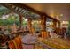 Inviting covered patio with stone columns, comfortable seating, and lush desert landscaping at 3416 E Squawbush Pl, Phoenix, AZ 85044