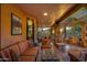 Charming covered patio with stone pillars, comfortable seating, and views of lush landscaping at 3416 E Squawbush Pl, Phoenix, AZ 85044