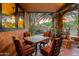 Cozy covered patio with a mosaic table, comfortable chairs, and views of desert landscaping at 3416 E Squawbush Pl, Phoenix, AZ 85044