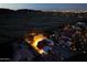 Stunning aerial view of a white single-Gathering home with lighted basketball court and city views at dusk at 3738 E Kachina Dr, Phoenix, AZ 85044