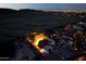 Aerial view of a home at night, showcasing the outdoor lighting and surrounding desert landscape at 3738 E Kachina Dr, Phoenix, AZ 85044