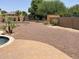 Backyard featuring mature trees, privacy walls, and low-maintenance landscaping at 42468 W Palmyra Ct, Maricopa, AZ 85138