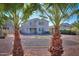 View of the home's backyard featuring palm trees and landscaping at 42468 W Palmyra Ct, Maricopa, AZ 85138