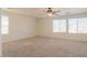 Spacious bedroom with neutral carpet and a ceiling fan at 42468 W Palmyra Ct, Maricopa, AZ 85138