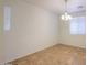 Bedroom showcasing neutral walls, modern light fixture, and a view of the window at 42468 W Palmyra Ct, Maricopa, AZ 85138
