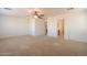 Spacious bedroom featuring neutral carpet, ceiling fan, and access to a bathroom at 42468 W Palmyra Ct, Maricopa, AZ 85138