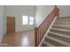 Foyer area with a staircase featuring wooden banisters and tile floors at 42468 W Palmyra Ct, Maricopa, AZ 85138