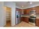 Bright kitchen featuring stainless steel appliances, pantry and sleek countertops at 42468 W Palmyra Ct, Maricopa, AZ 85138