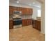 Kitchen with stainless steel appliances, backsplash and dark wood cabinets at 42468 W Palmyra Ct, Maricopa, AZ 85138