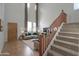 Virtual staging of a well lit room with a staircase, hardwood floors and neutral color palette at 42468 W Palmyra Ct, Maricopa, AZ 85138