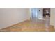 A view of the living room area with neutral color walls and tan tile flooring at 42468 W Palmyra Ct, Maricopa, AZ 85138