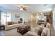 Bright, staged living room with modern furniture, ceiling fan, and open floor plan at 42468 W Palmyra Ct, Maricopa, AZ 85138
