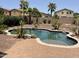 Inviting backyard oasis featuring a pebble tec pool and lush landscaping at 42468 W Palmyra Ct, Maricopa, AZ 85138