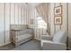 Cozy Bedroom showcasing a crib, chair, striped wallpaper, and framed pictures at 4925 S Turbine --, Mesa, AZ 85212