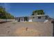A gravel-covered backyard with a mature shade tree and a view of the home's exterior at 5657 E Dallas St, Mesa, AZ 85205