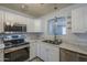 Bright kitchen featuring white cabinetry, stainless steel appliances, and marble countertops, perfect for cooking at 5657 E Dallas St, Mesa, AZ 85205