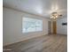 Bright living room with large window allowing natural light and beautiful hardwood floors at 5657 E Dallas St, Mesa, AZ 85205
