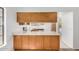 Bright kitchen with a breakfast bar featuring wooden cabinetry and quartz countertops at 6602 W Ironwood Dr, Glendale, AZ 85302