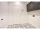 Clean laundry room with overhead cabinets, patterned floor, and access to the exterior at 7214 E Rustling Pass, Scottsdale, AZ 85255